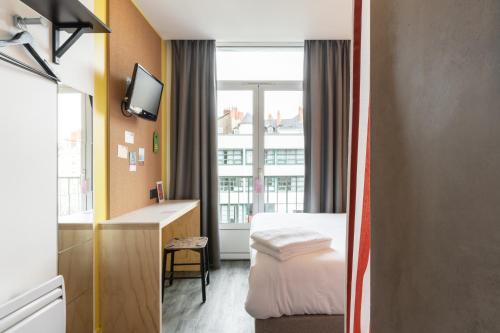 南特DEMAIN Hôtel & Conciergerie的酒店客房设有床和窗户。