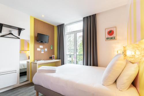 南特DEMAIN Hôtel & Conciergerie的酒店客房设有床和窗户。