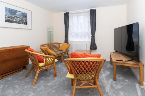 爱丁堡Brilliantly Located 2BD Flat Heart of Edinburgh!的客厅配有椅子和平面电视