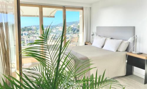 马略卡岛帕尔马Hotel Apartment with Breathtaking Panoramic Sea and Mountain Views的一间卧室设有一张床和一个大窗户