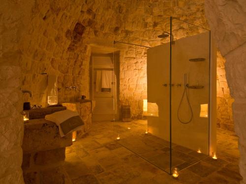 塞尔瓦迪法萨诺Nina Trulli Resort的石头建筑中带淋浴的浴室