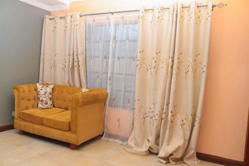 MeruTamwe ltd agency的一间带椅子和窗帘的窗户的房间