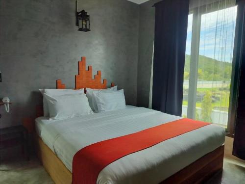 北碧Cicada Hotel Kanchanaburi的一间卧室设有一张大床和大窗户