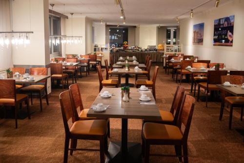 汉堡格拉夫莫尔汉堡新奇酒店的用餐室配有桌椅