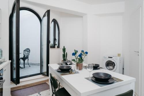 那不勒斯Vista Napoli Residence - Il Cortile的白色的厨房,配有一张桌子和两个碗