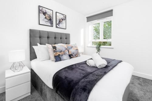 伯明翰Smethwick Deluxe 2 Bedroom Aparetment - Secure Parking - Balcony - Rated Exceptional - 9MC的白色卧室配有一张带白色床单和枕头的大床