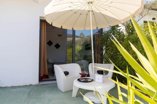 卡尔德杜Natur Hotel Tanca的桌椅、雨伞和酒杯