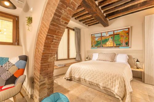 蒙特普齐亚诺Palazzo Falcinelli Luxury Room in Montepulciano Air Conditioning and Elevator的一间卧室设有一张床和砖墙