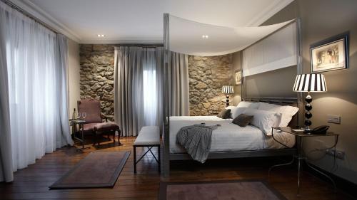 彼蒂高伊恩伊利亚特约热吉亚酒店的一间卧室设有一张床和石墙