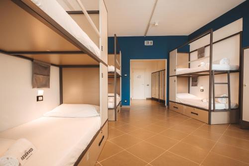 莱科Lecco Hostel & Rooms的宿舍间设有两张双层床和蓝色的墙壁。