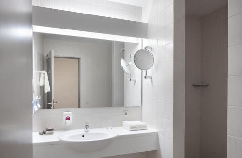 海德柏林诺迪卡酒店的白色的浴室设有水槽和镜子