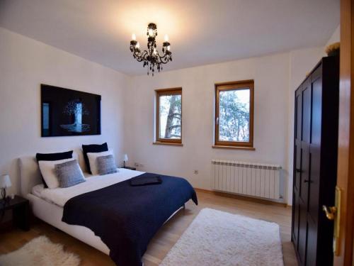 萨格勒布WOLKENHAWK的一间卧室配有一张大床和一个吊灯。