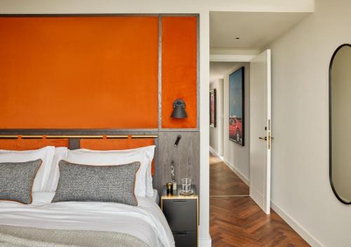 托斯特Escapade Silverstone的一间卧室配有橙色床头板和白色的床