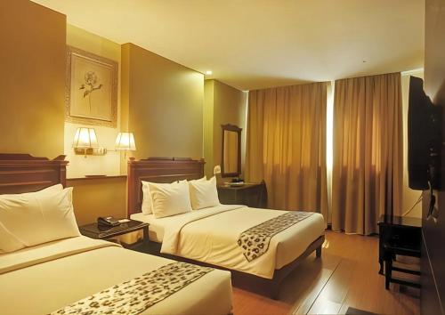 古晋潘维酒店的酒店客房设有两张床和电视。