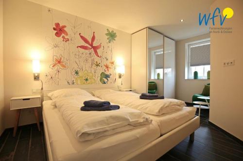 万根沃格Bootshaus in den Duenen - 1 Ferienwohnung "Unter Fischen"的一间卧室配有一张带两个枕头的床