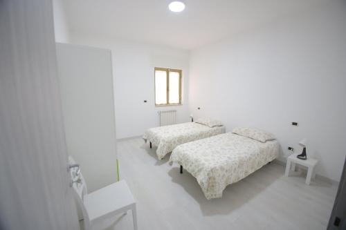 San Ferdinando di PugliaIl nascondiglio的白色的客房设有三张床和窗户。