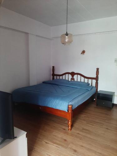 彭世洛อพาร์ทเม้นท์บ้านสบาย的一间卧室配有一张带蓝色毯子的床