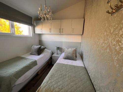 博文卡尔斯佩尔Vakantie Villa Markermeer的一间卧室配有两张床和吊灯。