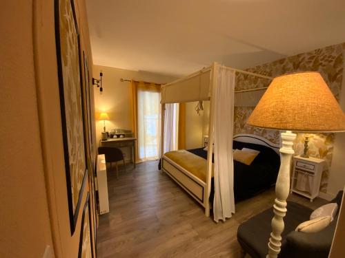 Commensacq杜曼德拉贝鲁住宿加早餐旅馆的一间卧室配有天蓬床和一盏灯。