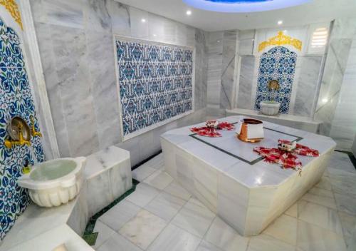 基兹洛特Armas Pemar Beach的浴室铺有蓝色和白色的瓷砖,配有浴缸。