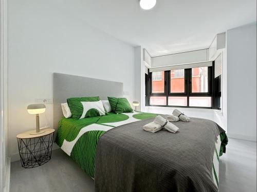 拉科鲁尼亚Housingcoruña Cantabrico的一间卧室配有一张带绿色床单的大床