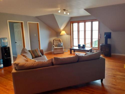 Saint-Laurent-de-l'ile d'Orleans勒皮蒂特博纳尔旅舍的客厅配有沙发和桌子