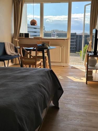 埃贝尔托夫特Udsigten.的一间卧室配有一张床、一张桌子和一架钢琴
