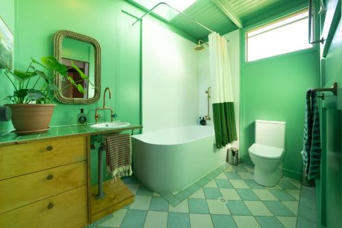赫斯基森Shell House The South Coast Sandcastles in Huskisson的绿色浴室设有浴缸和卫生间