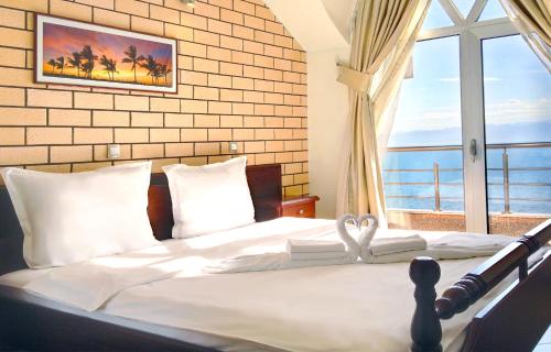 奥赫里德帝景别墅酒店的一间卧室设有一张大床和大窗户