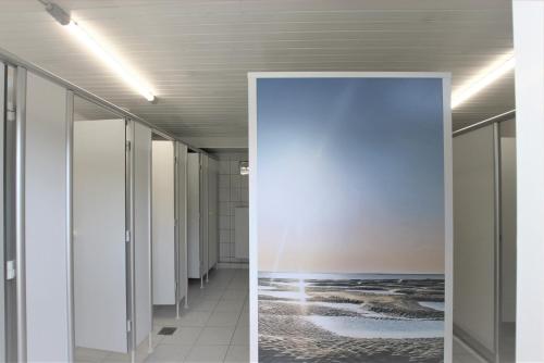 库克斯港Strandgut Kajüte的一条空的走廊,上面有一幅海洋画