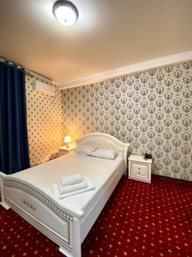ZaozërnyyГостиничный комплекс Белес的卧室配有白色的床和红色地毯