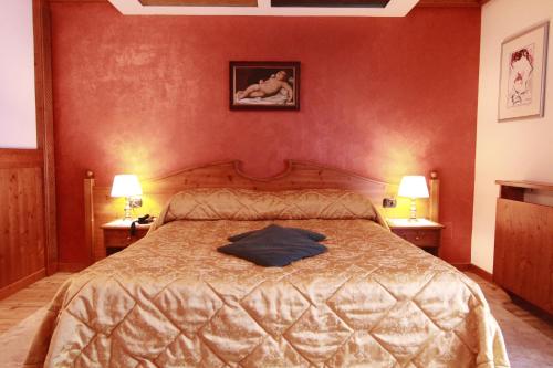 圣马蒂诺-迪卡斯特罗扎G. Hotel Des Alpes (Classic since 1912)的一间卧室,床上有蓝色衬衫