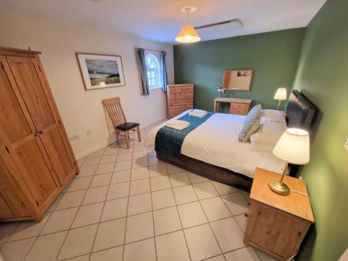 莱顿巴泽德Town End的一间卧室设有一张特大号床和绿色的墙壁