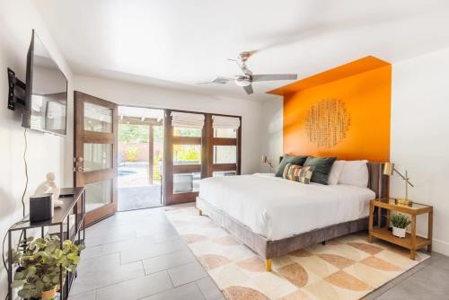 斯科茨Heated Pool Outdoor Kitchen Patio Modern Design的一间卧室设有一张床和橙色的墙壁