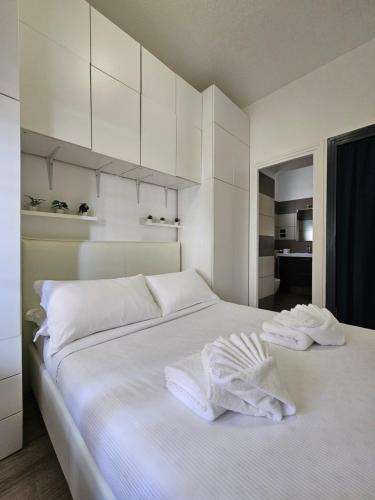 罗马ROME HOLIDAY QUIET AND CONFORTABLE APARTMENT的一间白色卧室,床上配有2条毛巾