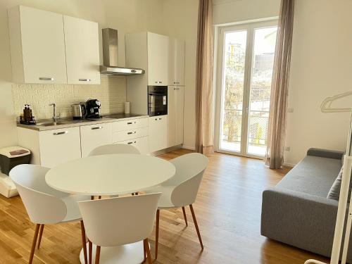 米兰Bocconi Navigli -La casa di Zoe with free Netflix and WiFi的厨房配有白色的桌椅和桌子