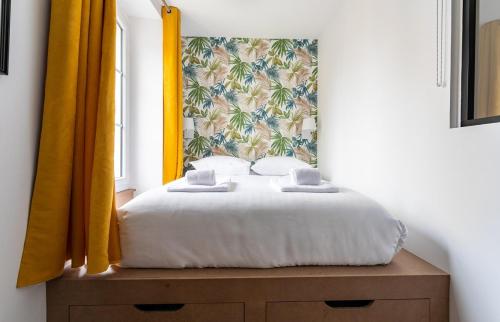 迪纳尔Lucelyne - Beau T2 rénové - Centre - Plage 400m的一间卧室配有一张黄色窗帘的床