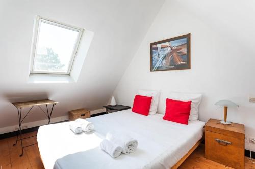 迪纳尔Le Capucin - Petit duplex avec place de parking的两张床铺,带两个红色枕头