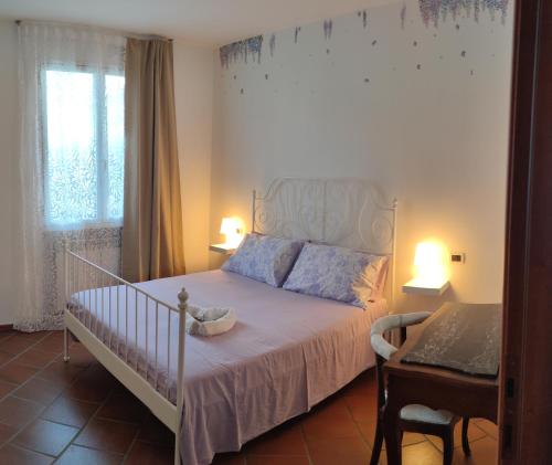 波吉La casa di Giada的卧室配有白色的床和窗户。