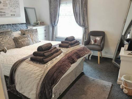 麦克尔斯菲尔德Stunning 2-Bed House in Macclesfield Cheshire的一间卧室配有一张带棕色毛巾的床