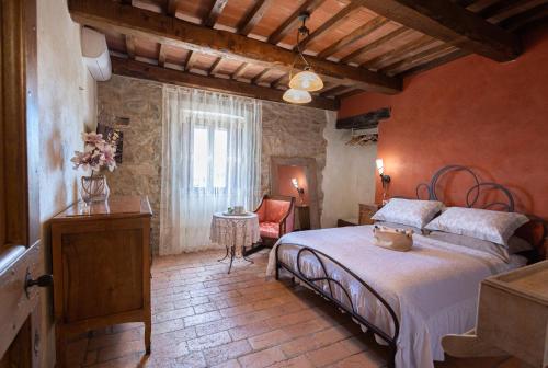 特拉西梅诺湖畔帕西尼亚诺Di Colle in Colle - Agriturismo的一间卧室,卧室内配有一张床和一把椅子