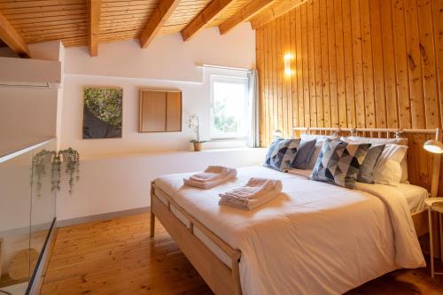 塔维拉Quinta da Capelinha Agroturismo的一间卧室配有带毛巾的床