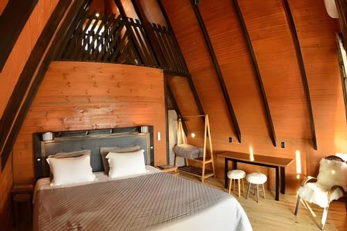 坎巴拉Chalé Vista do Vale的一间卧室设有一张大床和木墙