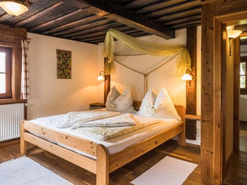 金德贝格Streuobsthof Weissenbacher的一间卧室配有一张木床和天篷