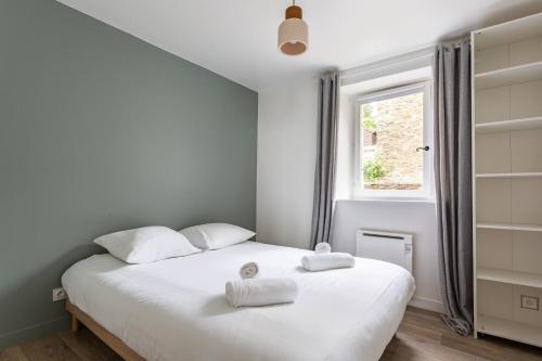 康卡勒La Brise- Joli T2 rénové - Vue Mer - 1 chambre的卧室配有白色床和毛巾