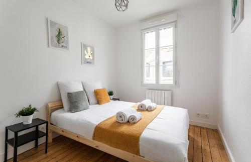 圣马洛Le Gardelle - Jolie maison de ville (2 chambres)的一间卧室配有一张床,上面有两条毛巾