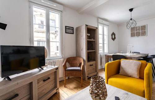 圣马洛Le Gardelle - Jolie maison de ville (2 chambres)的客厅配有平面电视和黄色椅子