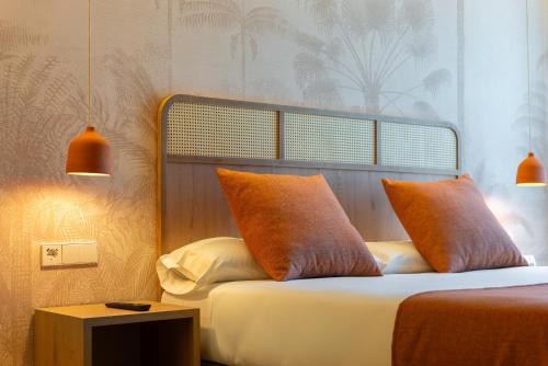 埃尔切千禧花园酒店的一间卧室配有带橙色枕头和桌子的床