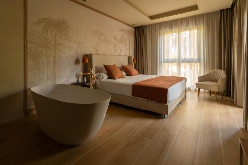 埃尔切千禧花园酒店的一间卧室配有一张床和一个浴缸。