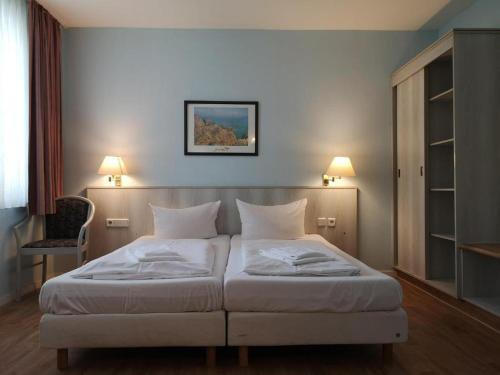 柏林阿尔特市场酒店的卧室配有带两盏灯的白色床